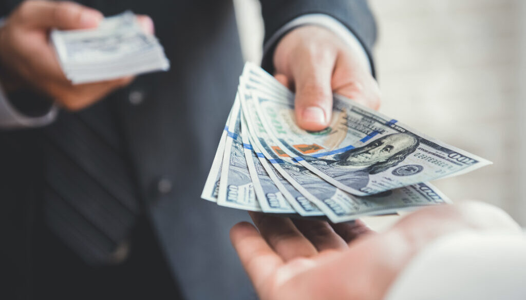 Businessman giving or paying money to a man
